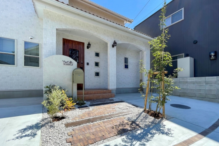 オリーブ色のポストと小鳥の表札がアクセントのナチュラルエクステリア