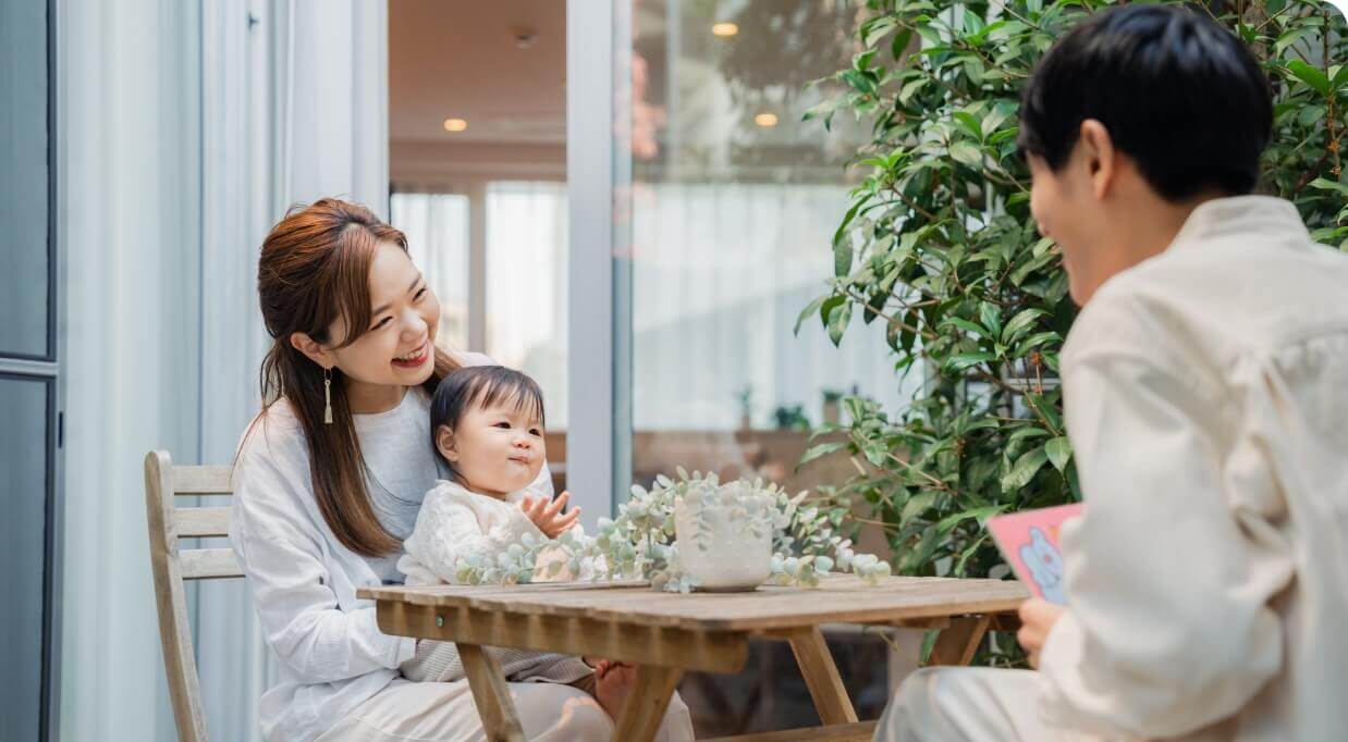 緑豊かな中庭で子どもとゆっくり過ごす若い夫婦