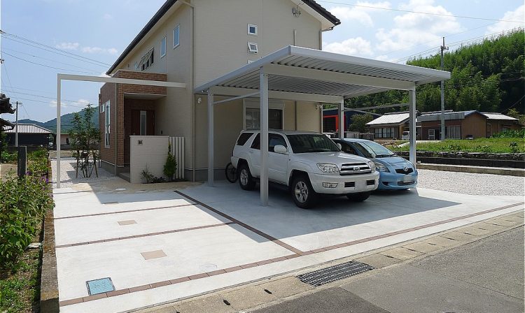 白の木調パネルの門柱とプラスGが演出する明るいエクステリア。